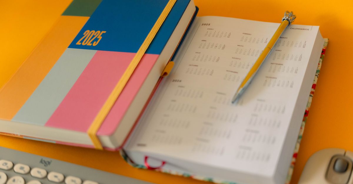 A colourful planner and calendar set up on a desk for organising a new routine