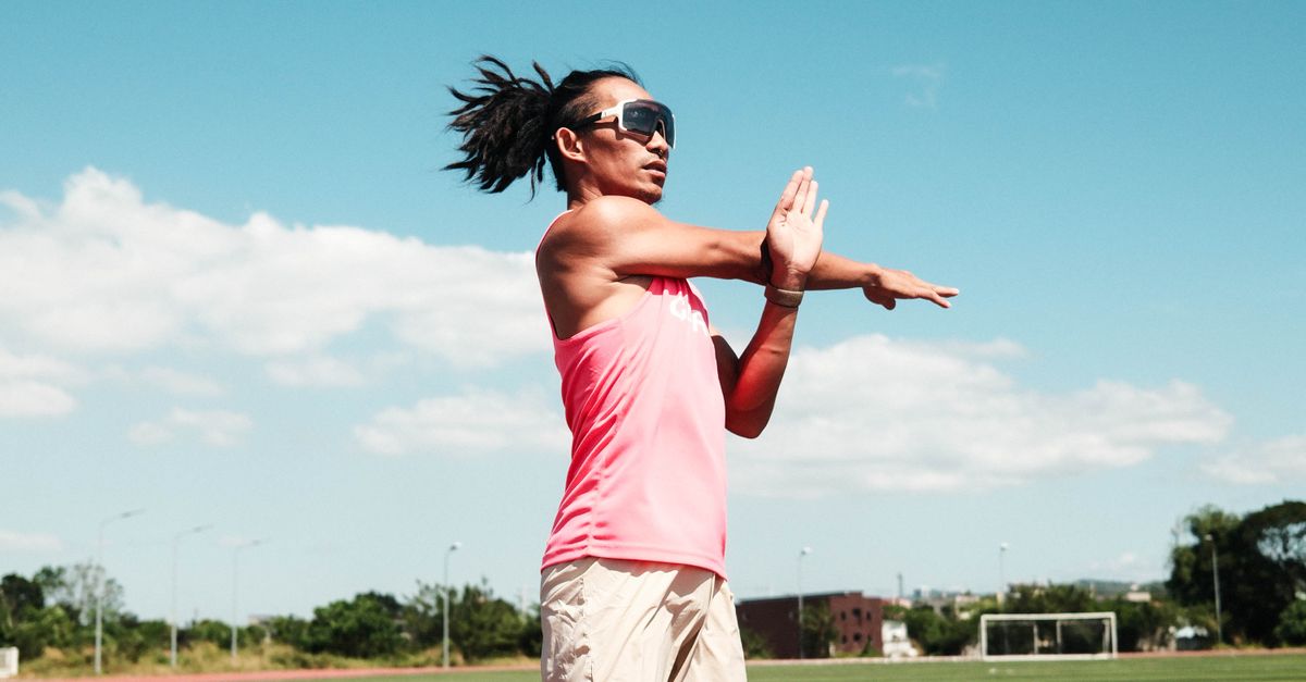 An athlete stretching on an outdoor running track