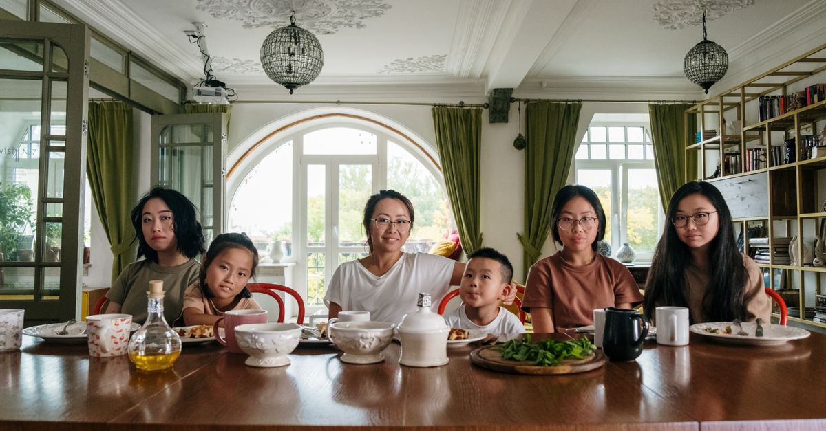 A diverse family enjoying dinner together in a cozy living room setting