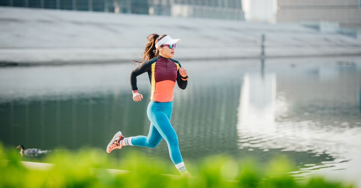 A woman jogging outdoors in bright sportswear