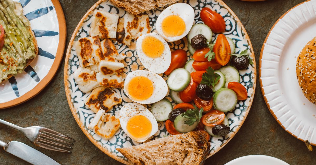 A vibrant Mediterranean-style savoury breakfast plate with eggs, halloumi and fresh vegetables
